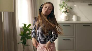 wenig Mädchen Tochter Kind Kind im Kopfhörer Hören Musik- genießen komisch Wochenende Schülerin kabellos Bewegung Tänzer Zeitvertreib Unterhaltung Gerät Schüler Vorschule jung Frau Liebling Lied positiv Energie video