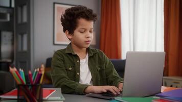 African American son male kid child boy pupil student schoolboy study at home typing browsing laptop computer studying distant learning homework e-learning play game online education internet using video