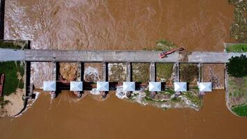 Aerial view of the dam's floodgates with rapid flow of water in the rainy season. Dam water release, dam overcapacity after heavy rain. video
