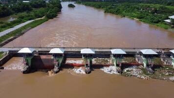 aéreo Visão do a barragem comportas com rápido fluxo do água dentro a chuvoso temporada. barragem água liberar, barragem excesso de capacidade depois de pesado chuva. video