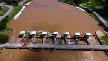 aéreo Visão do a barragem comportas com rápido fluxo do água dentro a chuvoso temporada. barragem água liberar, barragem excesso de capacidade depois de pesado chuva. video