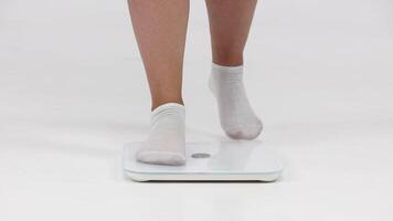 Full-figured woman standing on a scale displaying her weight, set against a light background. Perfect for promoting a mindful approach to weight loss and healthy living video