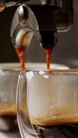 Process of making coffee coming out from an automatic professional coffee maker machine. Modern coffee machine with glass cup of latte. Beverage drink for breakfast. High quality vertical shot video