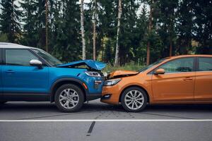 Blue SUV and orange sedan in minor collision, side by side contact visible photo