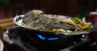 Fried white pomfret is a must-have New Year dish In Vietnam, delicious fish is cooked in a frying pan in a restaurant, immediately cooked in front of customers, boiling and bubbling in water video
