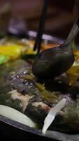 Fried white pomfret is a must-have New Year dish In Vietnam, delicious fish is cooked in a frying pan in a restaurant, immediately cooked in front of customers, boiling and bubbling in water video