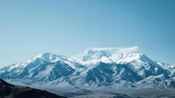 The mountains are covered in snow and the sky is clear and blue photo