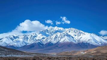 The mountains are covered in snow and the sky is clear and blue photo