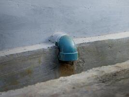 Water dripping from a drain pipe in a ditch photo