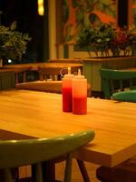 Sauce and mustared bottles at restaurant table photo