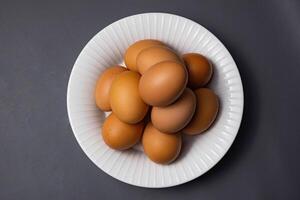 Chicken eggs in plate isolated on grey background with clipping path. Close up with selective focus photo