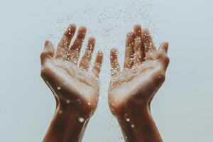 A pair of sweaty hands with water droplets splashing around them. photo