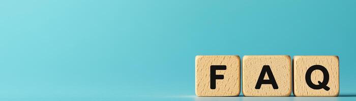 Creative FAQ sign displayed with wooden blocks on a light turquoise background, emphasizing information and clarity in communication. photo