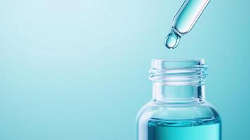 A clear glass bottle with a pipette, showcasing a drop of blue liquid, perfect for health or beauty product visuals. photo