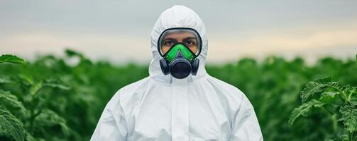 A worker in protective gear stands in a lush green field, emphasizing safety in agriculture and environmental protection. photo