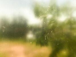 Abstract blurred nature scene through a dusty glass window. Perfect for background textures and artistic designs photo