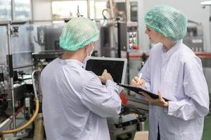 quality supervisor or food or beverages technician inspection about condition control food or beverages before send product to the customer. Production leader recheck machine and productivity. photo