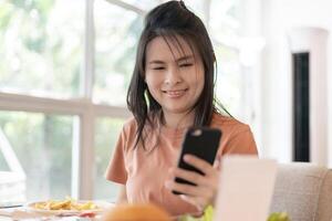 Woman use smartphone to scan QR code for order menu in cafe restaurant with a digital delivery. Choose menu and order accumulate discount. E wallet, technology, pay online, credit card, bank app. photo