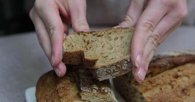 baguette of black rye bread lies on a wooden table, next to cut pieces of baguette. Panorama. The concept of baking, fresh fragrant bread to the table video