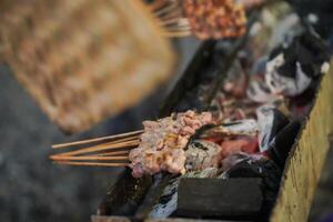 sate kambing or satay goat, lamb, Lamb or meat goat satay with charcoal ingredient on red fire grilling by people. traditional satay from yogyakarta, java, Indonesia cooking satay photo