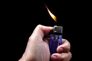Turn on a gasoline lighter on a black background photo