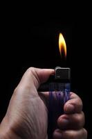 Turn on a gasoline lighter on a black background photo
