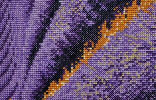 Purple, violet and brown close-up cross stitch background. Abstract Embroidered handmade Pattern. Needlework and DIY concept. Top view, macro, flat lay, mockup. photo
