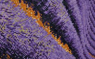 Purple, violet and brown close-up cross stitch background. Abstract Embroidered handmade Pattern. Needlework and DIY concept. Top view, macro, flat lay, mockup. photo