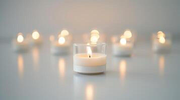 Lone candle shining brightly in the front with multiple other candles out of focus in the background photo