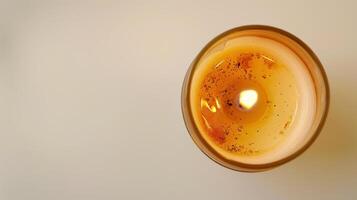 Close-up of a scented candle with a warm, inviting flame, creating a cozy ambiance photo