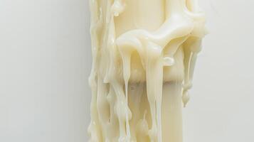White candle melts, forming intriguing patterns as the wax drips down the side photo