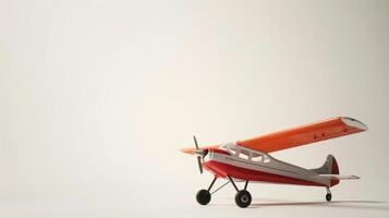 Little orange and white toy plane sits on a white surface with a simple white backdrop photo