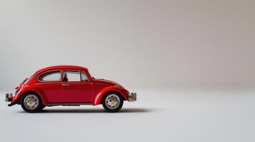 Evocative red toy car stands on a white background, symbolizing childhood, play, and nostalgia photo
