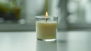 Peaceful and relaxing atmosphere is created by the bright flame of a small glass candle photo