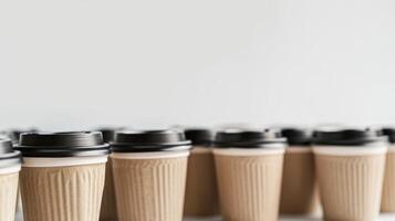 Disposable paper coffee cups with black lids lined up, showcasing a popular drink option photo