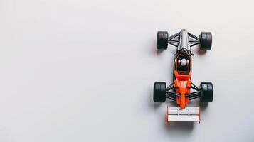 Black and orange toy race car displayed on a white background with empty space to the side photo