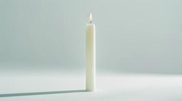 Serene scene with a single white candle burning against a pure background photo
