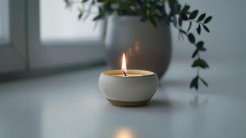 Handcrafted ceramic candle burns, creating a cozy glow and a peaceful ambiance photo