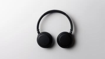 Black wireless headphones resting on a clean white surface with a minimalist design photo