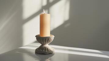 Softly burning candle on a white surface creates a peaceful atmosphere photo