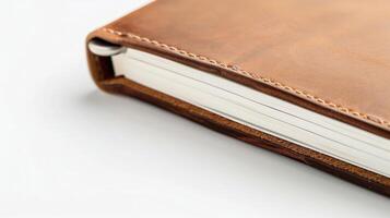 Showing a brown leather bound notebook with its white pages slightly fanned open photo