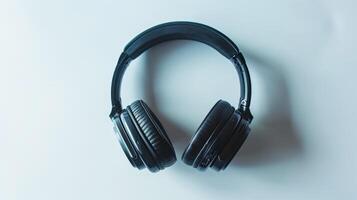 Black wireless headphones resting on a white surface, symbolizing music, podcasts photo