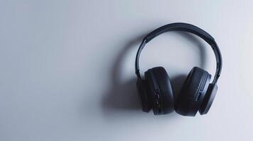 Set of black wireless headphones rests on a clean white surface, evoking a minimalist style photo