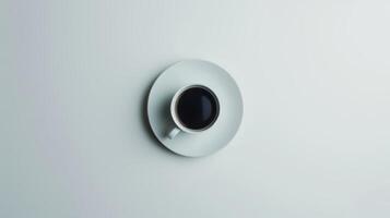 Steaming cup of coffee sits in a white mug on a matching saucer photo
