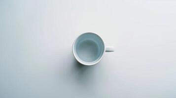 Simple white coffee mug rests on a white surface, creating a sense of minimalism and simplicity photo