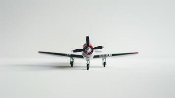 Toy airplane is placed on a white surface with its propeller facing forward photo