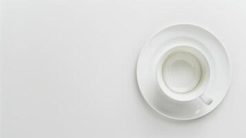 White coffee cup and saucer rest on a blank white surface, exuding a sleek and minimalistic vibe photo