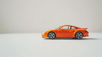 Vibrant orange toy car against a clean white background in a studio photo
