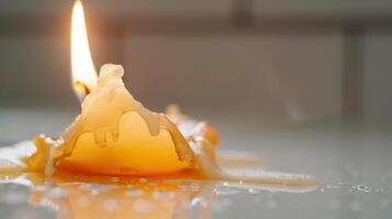 White candle burns and melts, forming intriguing wax shapes on a table photo