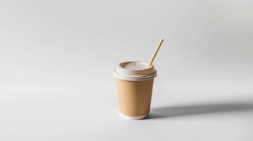 Paper coffee cup with a straw is placed on a white surface, creating a faint shadow photo